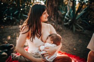 Mamá amamantando tranquila a su bebé al aire libre